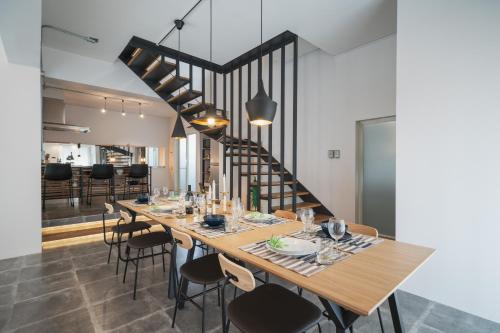 a dining room with a table and chairs and a staircase at INFINITY HOTEL -Higawa- in Naha