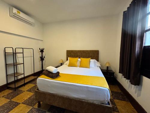 a bedroom with a large bed with yellow pillows at Hotel Boulevard del Río in Cali