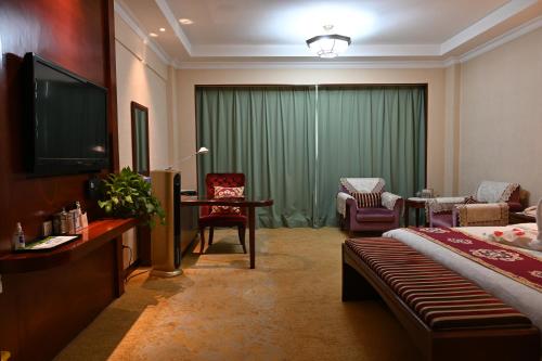 a hotel room with a bed and a television at Dunhuang Hotel in Dunhuang