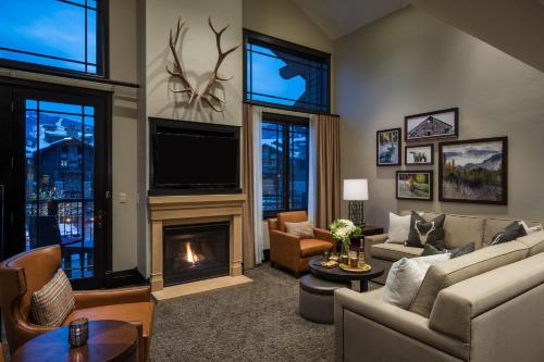 a living room with a fireplace and a tv at Waldorf Astoria Park City in Park City
