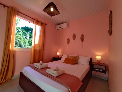 a bedroom with a bed with towels on it at Location Touristique Des Tortues in Deshaies