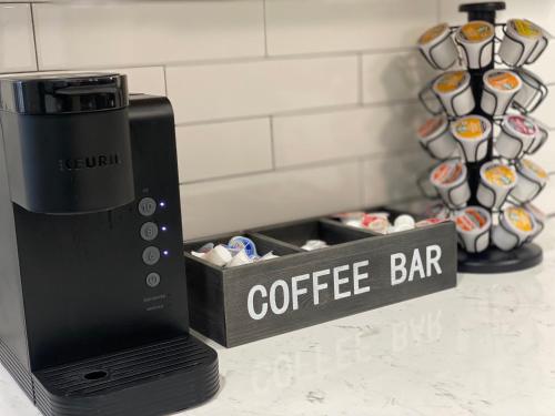 a coffee bar sign next to a coffee maker at Optimum - Uptown Oasis in Birmingham