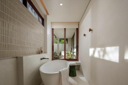 a bathroom with a white tub and a sink at Barcelo Coconut Island, Phuket in Phuket Town
