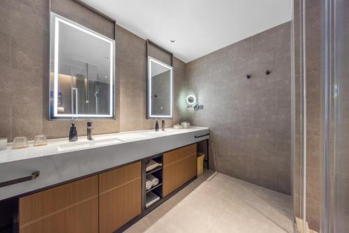 a bathroom with two sinks and a large mirror at Atour Hotel Wefang High Tech Zone Management Committee East Jiankang Street in Weifang