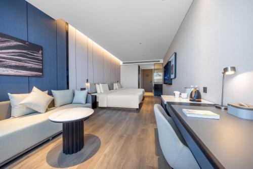 a hotel room with a couch and a table at Atour Hotel Wefang High Tech Zone Management Committee East Jiankang Street in Weifang