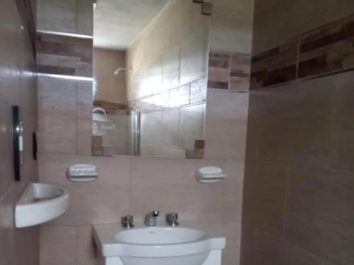 a bathroom with a sink and a toilet and a mirror at Posada Entre Dos in Mina Clavero