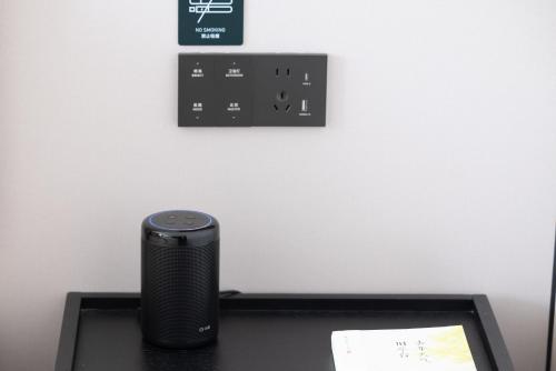 a black speaker sitting on top of a desk at Atour Hotel Wefang High Tech Zone Management Committee East Jiankang Street in Weifang