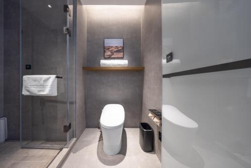 a bathroom with a toilet and a glass shower at Atour Hotel Wefang High Tech Zone Management Committee East Jiankang Street in Weifang