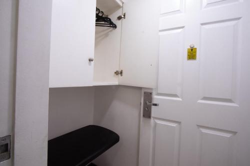 a white door with a black stool in a room at Hotel Sogo Kalentong in Manila