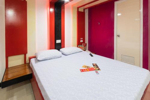 a bedroom with a large white bed with two magazines on it at Hotel Sogo Kalentong in Manila