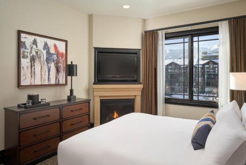 a bedroom with a bed and a fireplace and a television at Waldorf Astoria Park City in Park City