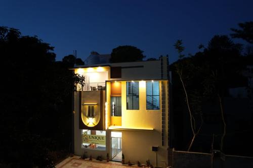 a house lit up at night with lights on it at Unique3 in Yercaud