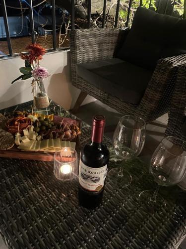 a bottle of wine sitting on a table with wine glasses at Tatala Hotel & Garden in Tepoztlán