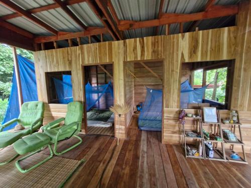 a room with a tent with green chairs and a bed at Green Garden Food Forest Buriram in Ban Thung Nak