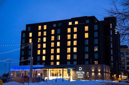 a building with lights on in the snow at night at Delta Hotels by Marriott Thunder Bay in Thunder Bay