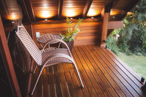 a porch with two chairs and a potted plant at Chalé Recanto do Vale pomerode in Pomerode