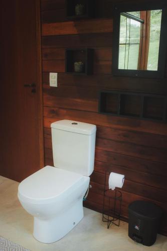 a white toilet in a room with a window at Chalé Recanto do Vale pomerode in Pomerode