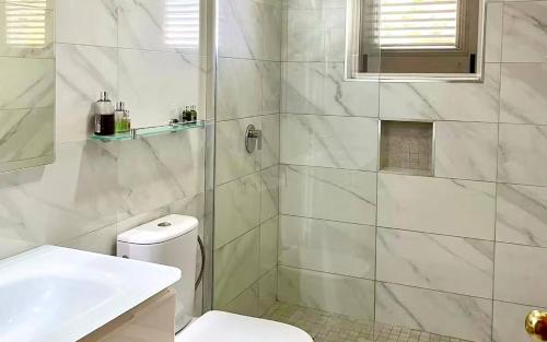 a white bathroom with a toilet and a sink at ZenBreak Kings Beach 12 in Saint Peter