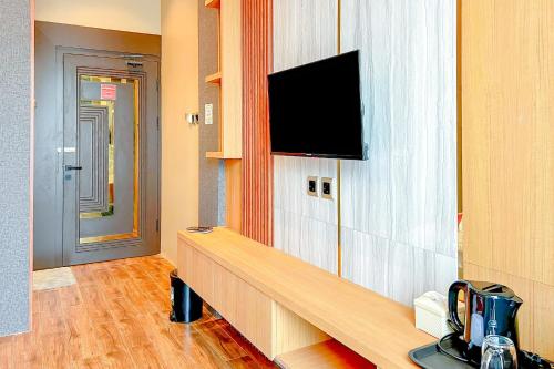 a room with a flat screen tv on a wall at RedDoorz Premium at Hotel Riyadi Syariah in Gunungcupu