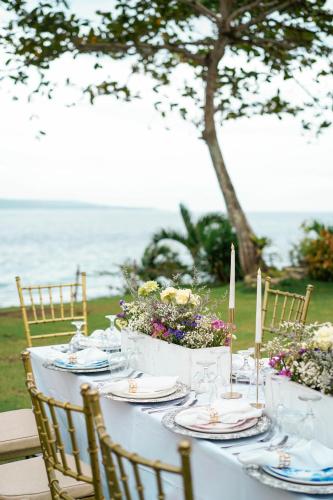 a white table with candles and flowers on it at Wuthering Heights Bed & Breakfast by the Sea in Dumaguete