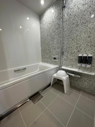 a bathroom with a white tub and a toilet at The land hotel L1 in Arao