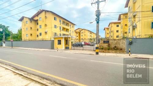 an empty street with yellow buildings in the background at Cop 30 apartamento compartilhado in Ananindeua