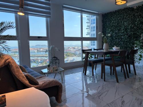 a living room with a table and chairs and windows at The Sands vista al mar Panamá avenida Balboa in Panama City