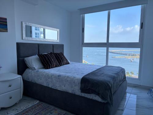 a bedroom with a bed with a view of the ocean at The Sands vista al mar Panamá avenida Balboa in Panama City