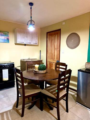 a kitchen with a wooden table with chairs and a dining room at Cabaña rincón del salto in Cabrero