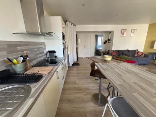 - une cuisine et un salon avec un comptoir et une table dans l'établissement Charmant 2P en Hyper Centre de Lorient - Lumineux avec Balcon - 2/3 Couchages. - FR-1-349-221, à Lorient