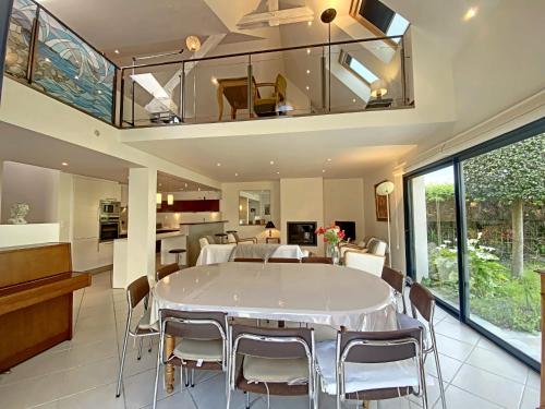 una sala da pranzo con tavolo e sedie bianchi di Maison familiale rénovée à 150m des criques, 4 chambres, jardin privé, cheminée, parking, WiFi - FR-1-349-222 a Port-Louis