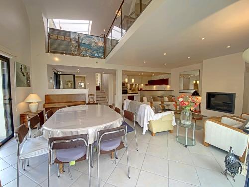 un grand salon avec une table et des chaises dans l'établissement Maison familiale rénovée à 150m des criques, 4 chambres, jardin privé, cheminée, parking, WiFi - FR-1-349-222, à Port-Louis