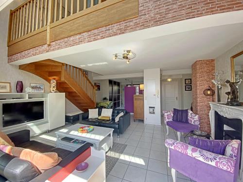 d'un salon avec des meubles violets et un escalier. dans l'établissement Penthouse au cœur de Lorient avec terrasses, spa, parking sécurisé et proche des plages - FR-1-349-225, à Lorient
