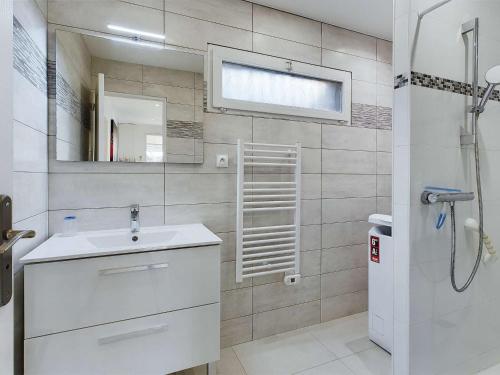 une salle de bain avec un lavabo blanc et une douche dans l'établissement Villa 3 chambres climatisée près de la plage avec parking privé à Marseillan-Plage - FR-1-326-845, à Marseillan