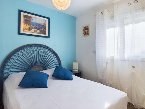 - une chambre bleue avec un lit et 2 oreillers bleus dans l'établissement Villa 3 chambres climatisée près de la plage avec parking privé à Marseillan-Plage - FR-1-326-845, à Marseillan