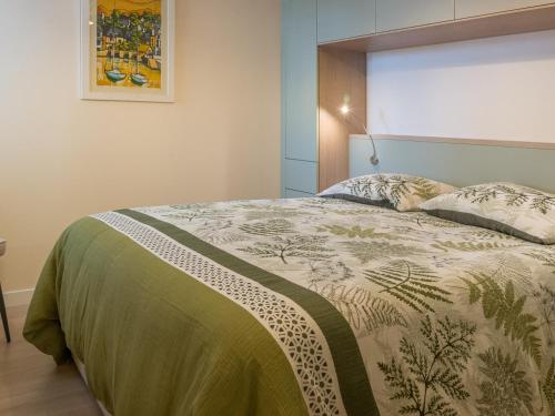 une chambre avec un lit avec une couette dessus dans l'établissement Appart T3, terrasse, parking, 50m plage, proche commerces - FR-1-349-228, à Larmor-Plage