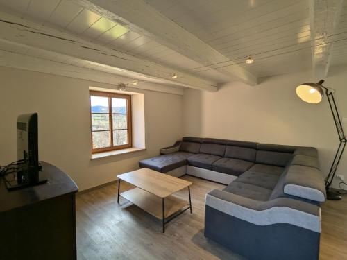 a living room with a couch and a table at Gîte familial de caractère pour 10 pers, vue vallée, proche ski - FR-1-589-790 in Fraize