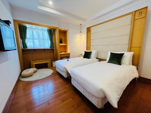a hotel room with two beds and a window at 旅行博物館 Hôtel du Musée in Taitung City