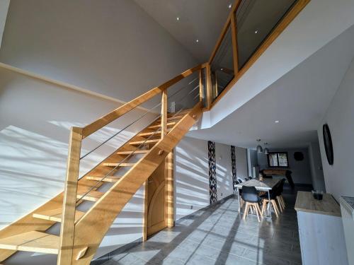 a wooden staircase in a house with a dining room at Gîte familial de caractère pour 10 pers, vue vallée, proche ski - FR-1-589-790 in Fraize
