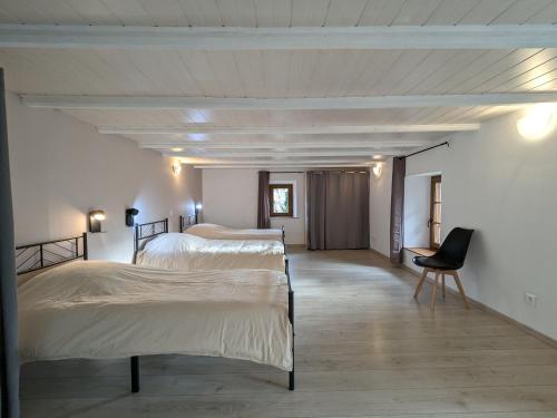 a bedroom with two beds and a chair in it at Gîte familial de caractère pour 10 pers, vue vallée, proche ski - FR-1-589-790 in Fraize