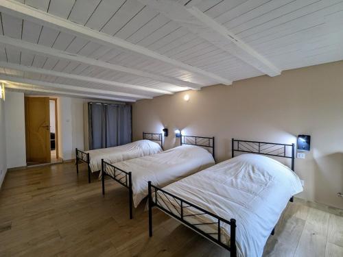 two beds in a room with white walls and wooden floors at Gîte familial de caractère pour 10 pers, vue vallée, proche ski - FR-1-589-790 in Fraize