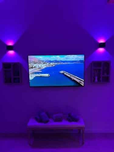 Cette chambre violette dispose d'une télévision murale à écran plat. dans l'établissement Secret & Jacuzzi, à Vienne