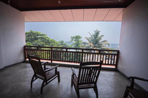 two chairs on a balcony with a view of the ocean at Talalla Breeze in Talalla