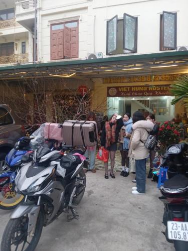 a group of people standing outside of a store with a motorcycle at VIỆT HƯNG HÀ GIANG Hostel motorbikes for rental in Ha Giang