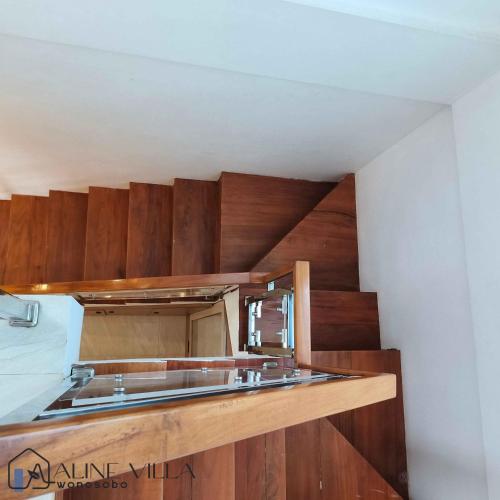 a kitchen with a sink and wooden cabinets at Aline Villa in Wonosobo