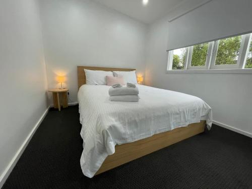 ローズバッドにあるPerfect Family Home pet-friendly in Rosebud plus BBQの白いベッドルーム(タオル付きのベッド付)