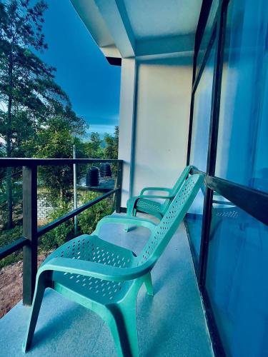 two green chairs on a balcony with a view at The Misty Mountain - Ella in Ella