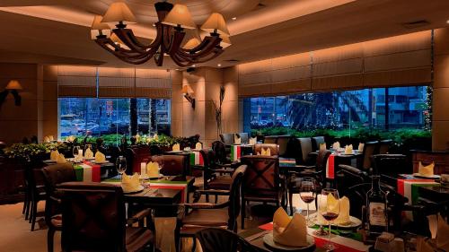 a restaurant with tables and chairs and a chandelier at Grand Noble Hotel Dongguan in Dongguan