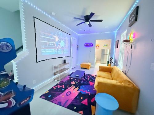 a living room with a couch and a large screen at Babyproofed, CinemaHome, TCU,DikciesArena,Stockyard,FortWorth in Fort Worth