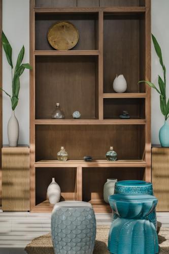 a display cabinet with vases and bowls on it at Maia Resort Quy Nhon in Quy Nhon